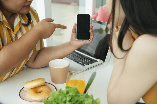 商务女性使用智能手机应用程序订购食品在线服务。复制空间。