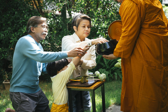 亚洲家庭早上向僧侣施舍。