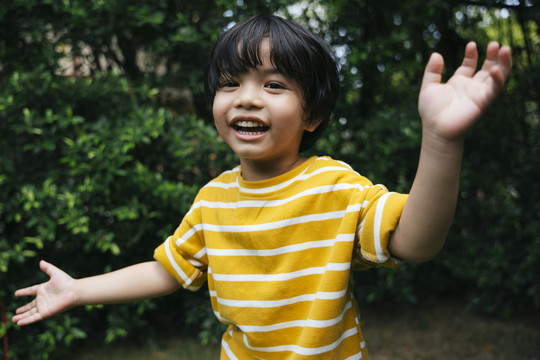 快乐的亚洲男孩在公园里欢笑的画像。