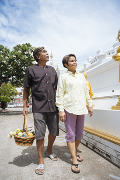 亚洲老年夫妇走在庙里做功。