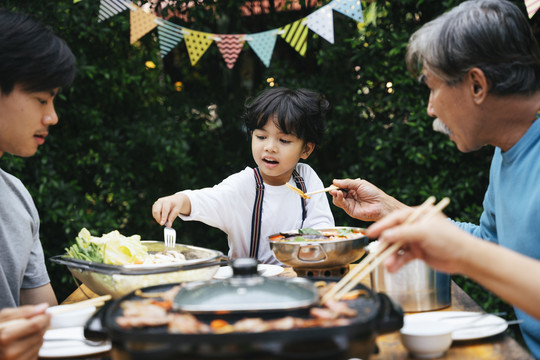 亚洲家庭喜欢在院子里吃烧烤庆祝生日聚会。