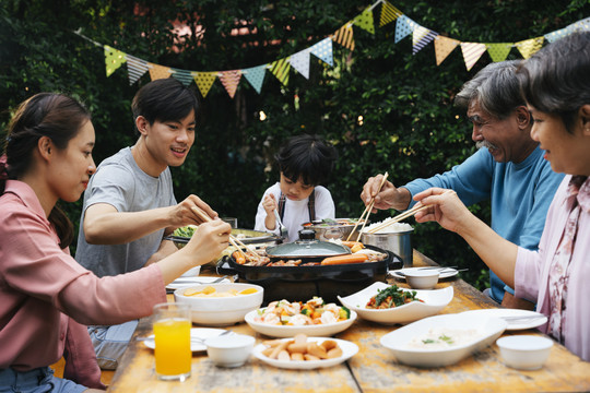 亚洲家庭喜欢在户外院子里一起吃烧烤。