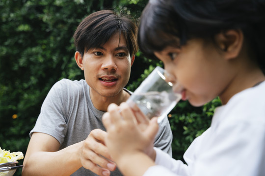 亚洲父亲在晚宴上给儿子喂淡水。