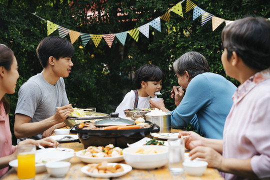 亚洲人喜欢在户外的院子里吃烧烤来庆祝聚会。