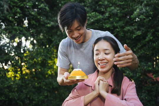 亚洲男人用金线甜点做生日蛋糕给女友惊喜。