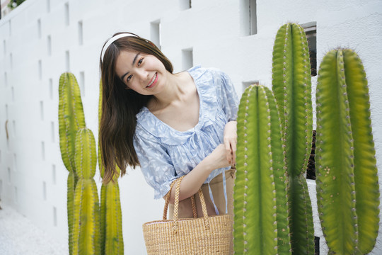 美丽的亚洲女游客在仙人掌农场提着篮子。