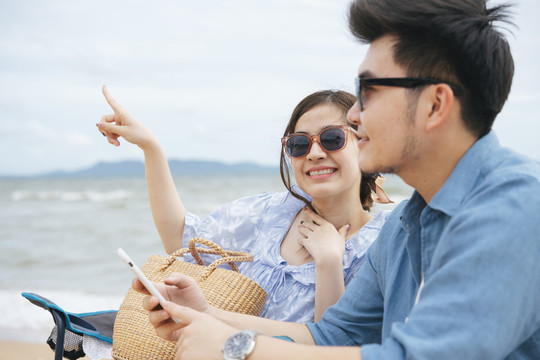 快乐浪漫的亚洲情侣在海滩旅行。