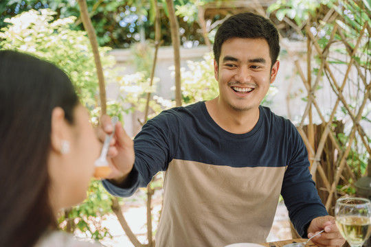 一名亚泰男子在餐厅吃午餐时喂爱人。