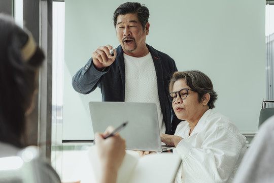 老首席执行官和秘书在会议室做报告。他在征求团队的意见。