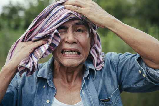 当地亚洲老年农民的特写肖像，头上戴着丝布。