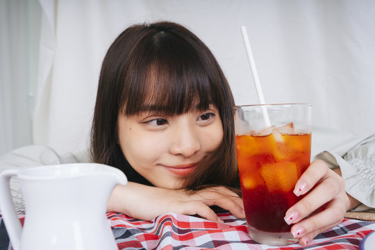 亚洲妇女手持泰国冰茶杯的特写照片。