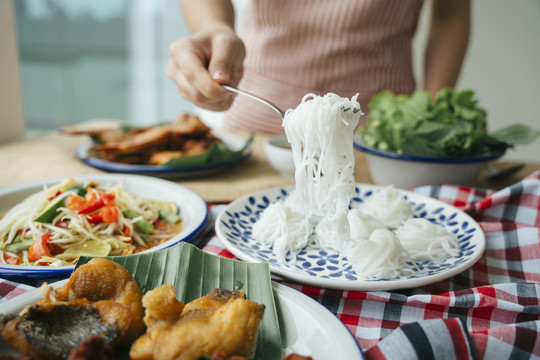 女人用叉子吃米粉的手。是一种食物概念。