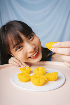 亚洲年轻女子吃泰国甜点金饼的特写镜头。