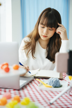 年轻的亚洲黑发女子在书评前写剧本。