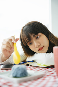 年轻的亚洲黑发女子用勺子吃甜糯米。