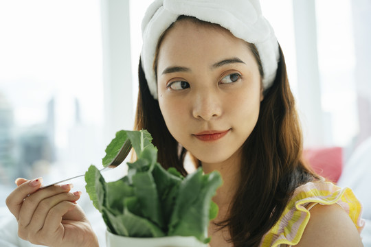 年轻的亚洲黑发白发女子喜欢吃有机蔬菜沙拉。