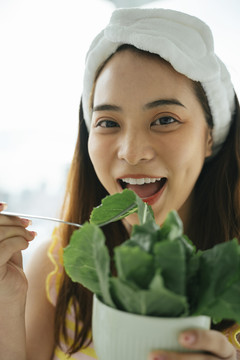 年轻的亚洲黑发白发女子喜欢吃有机蔬菜沙拉。