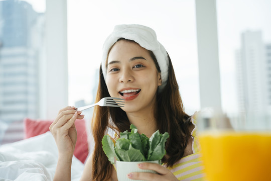 年轻的亚洲黑发白发女子喜欢吃有机蔬菜沙拉。