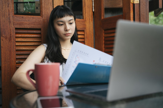 亚洲女商人早上在家里用笔记本电脑工作。