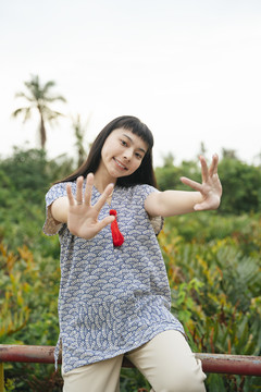亚洲黑发美女的肖像，在乡间展示两只手。