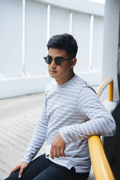 时尚写真-亚洲男人在城市户外戴太阳镜。