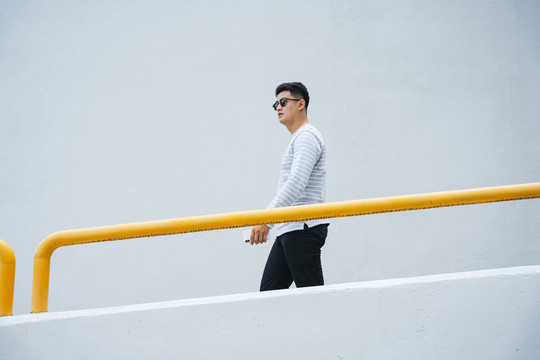 侧视图-时尚的亚洲成年男子戴太阳镜肖像。