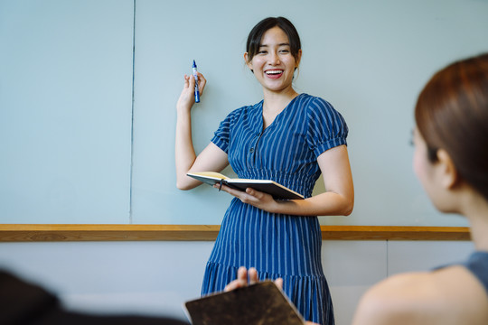 亚洲女商人在会议室做报告。