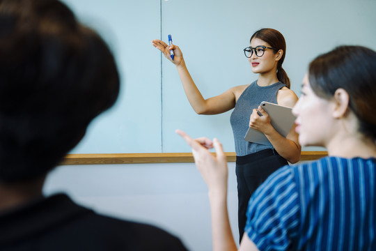 亚洲女商人在会议上做报告。