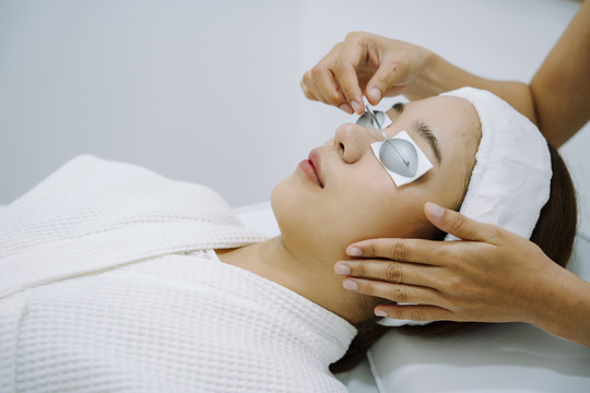 亚洲妇女在整容过程中使用护目镜进行面部水疗。