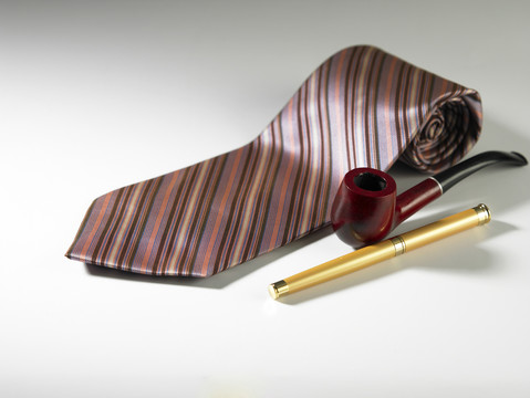 素色背景上的笔筒和领带
