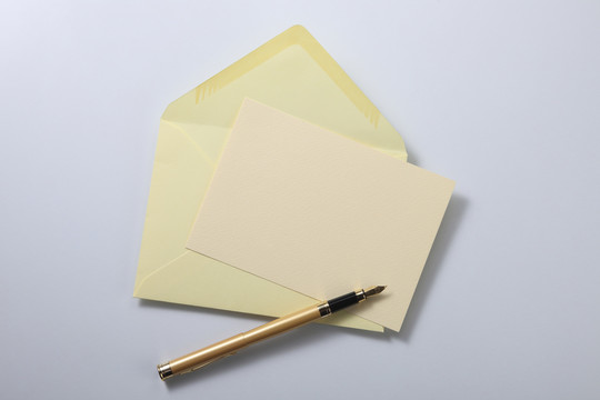 淡黄色信封信和笔