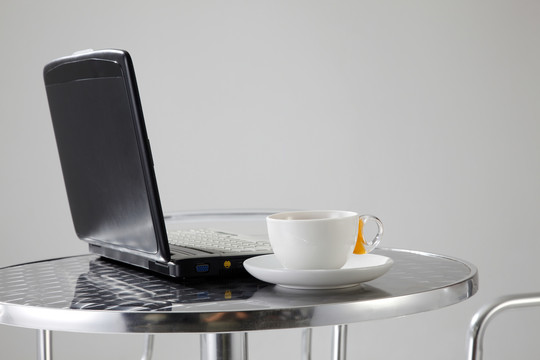 桌上有一台笔记本电脑和一杯咖啡