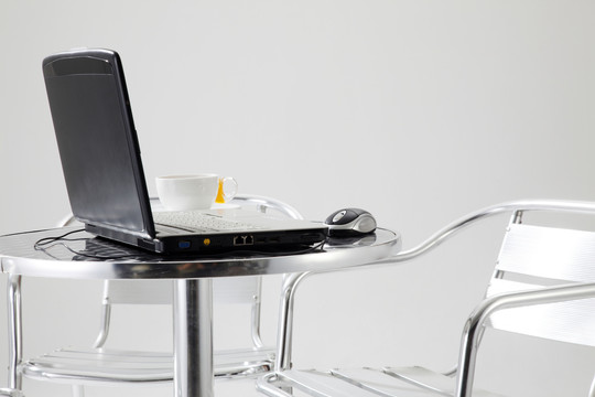 桌上有一台笔记本电脑和一杯咖啡