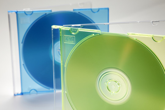 两张电脑或音乐cd，带绿色和蓝色cd盒和空白标签