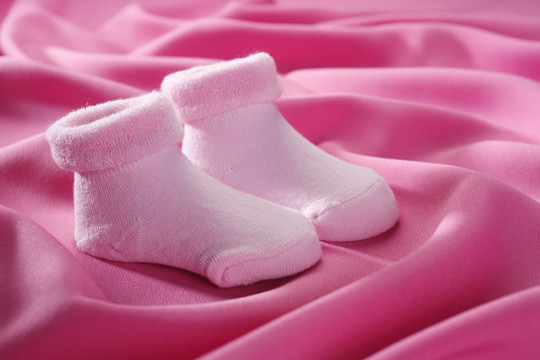 粉红色的袜子被隔离在粉红色的布上。