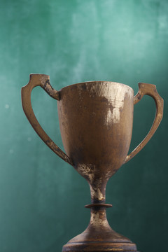 绿色背景上的青铜奖杯。