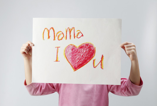 带留言板的小女孩的摄影棚照片“妈妈，我爱你”。