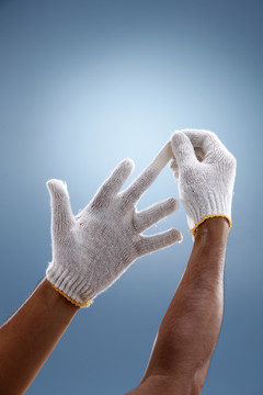 手戴上手套在一个创造性的蓝色背景。