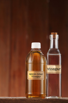 木制背景上的苹果醋和白醋