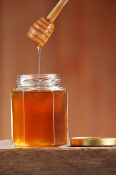 木制背景上的蜂蜜罐