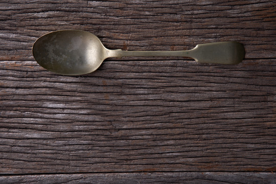 木制背景上的古董勺子