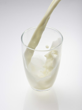 往杯子里倒牛奶或白色液体