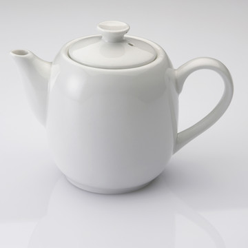 素色背景上的白茶壶特写