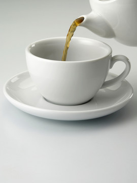 平淡背景上的茶杯和茶壶的特写镜头