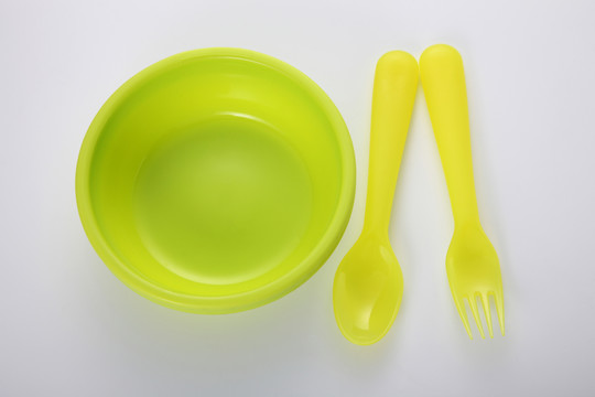 白色背景上的黄色塑料碗