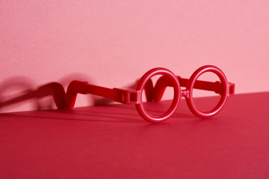 红色背景上的玩具红色圆眼镜