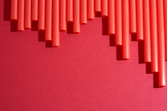 红色背景上的一排红色塑料吸管
