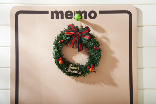 备忘录板上带有圣诞装饰的迷你松树花环俯视图