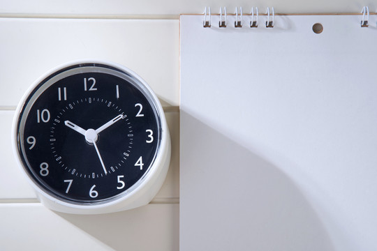 桌面日历2021和时钟放在木制办公桌上。日历为规划师制定时间表、日程安排、组织、管理表上的每一个日期