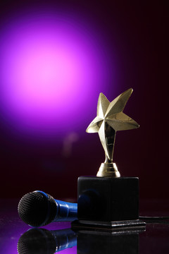 紫色背景上的明星奖杯和麦克风